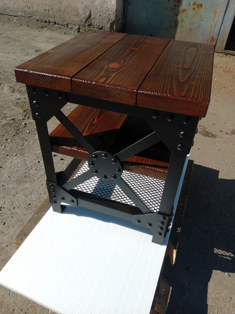 Ručně vyrobený odkládací stolek ve stylu steampunk s černým nýtovaným rámem, výztuhou X s kulatým nýtovaným plechem, smrkovou deskou a policí a spodní policí z ocelové mřížky