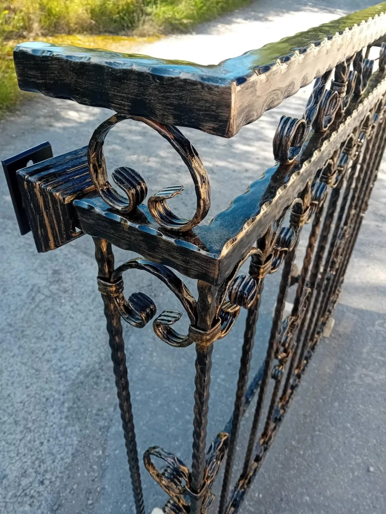 Detail kovaného zábradlí na francouzské okno – černá barva se zlatou patinou a ozdobné ornamenty