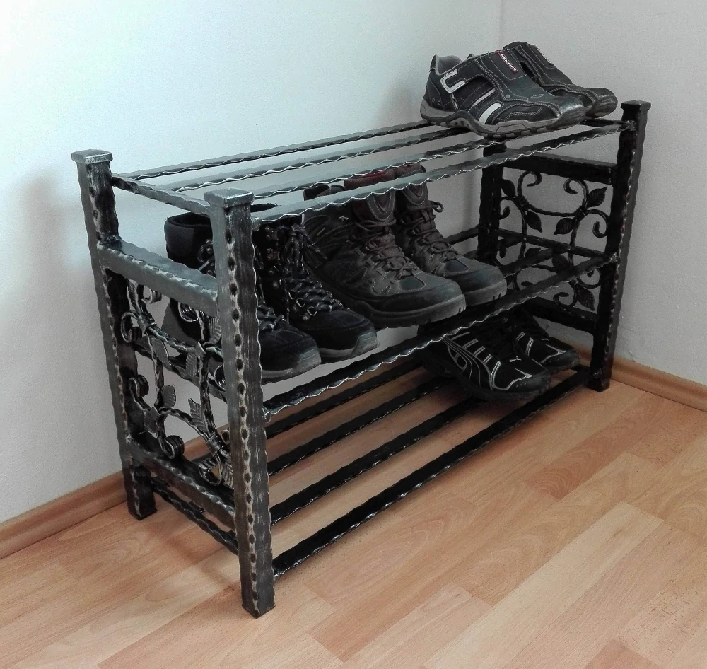 Černý kovový botník shora, roštové ocelové police s botami
